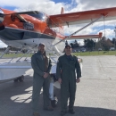 two people standing in front of an airplane