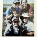 polaroid picture of 4 biologists holding ducks