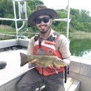 Image of biologist holding a fish in a boat.
