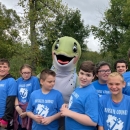 Group of kids smiling with fish mascot