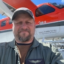Man (Ken Richkus) taking a selfie in front of a plane