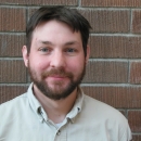 Man in FWS uniform with brick wall behind him.