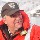 Man in orange life jacket looks to the right