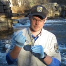 Person holding syringe and vile while on river.