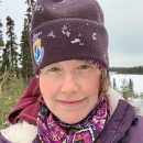 woman in brown hat and winter coat with snow flakes on her clothes