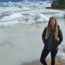 a woman standing by icy water