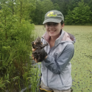 Picture of Hannah Gilbreath in the field holding an animal 