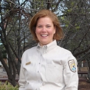 woman in FWS uniform, with trees in the background