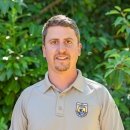 Service staff member, Michael Vargo, in uniform with trees in the background