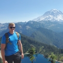 Man poses with white capped mountain in the background