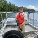 Man on boat holding catfish