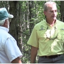 Steve talks with someone. Wearing a yellow polo. 