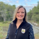 biologist in front of forest backdrop