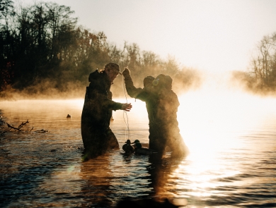 Waterfowl hunters in waders set up duck decoys in a North Carolina Wetland