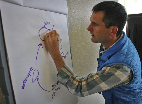 A man writes on a poster board