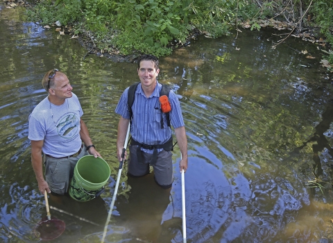 two men standing in a river