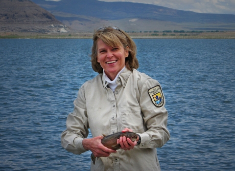 a woman holding a large fish