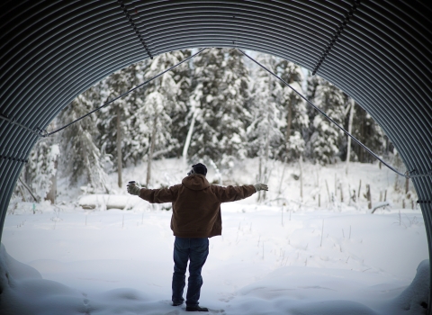 man standing in a large arch culvert