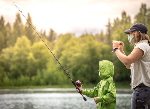 a woman helping a child fish