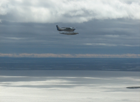 Airplane on amphibious floats flying over a lake