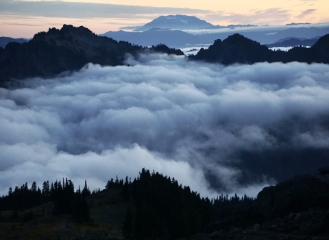 Fog-filled valleys looing toward a distant mountain