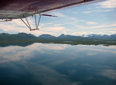 a sprawling lake with mountains in the background, as seen by a plance