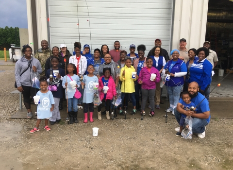 group photo of adults and kids with fishing rods