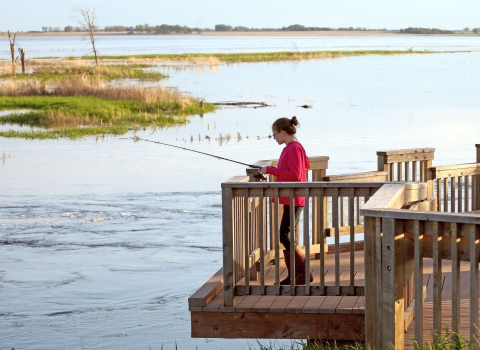 A young woman fishing from a platform