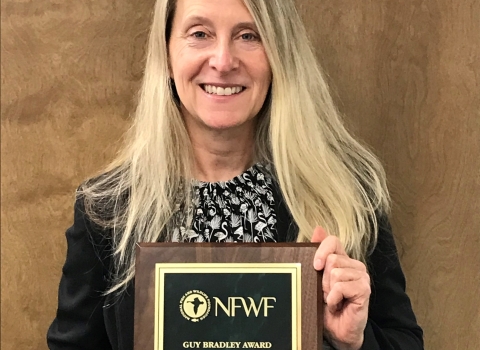 Person holding an award plaque.