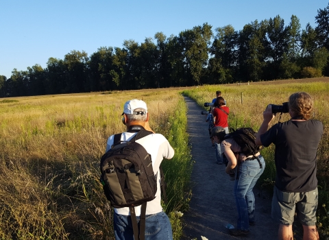 People looking out at the distance with camera and binoculars 