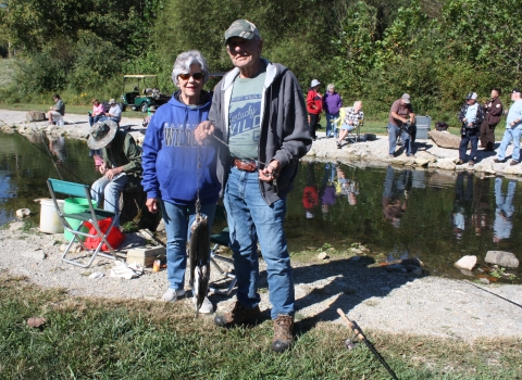 Senior couple smiling with a stringer full of Rainbow trout