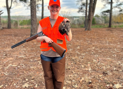 ACE Fellow Elena Campbell wearing blazing orange holds three quail she successfully harvested while hunting at Buckeyes Plantation. 