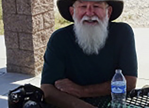 Man with white bear wearing a hat