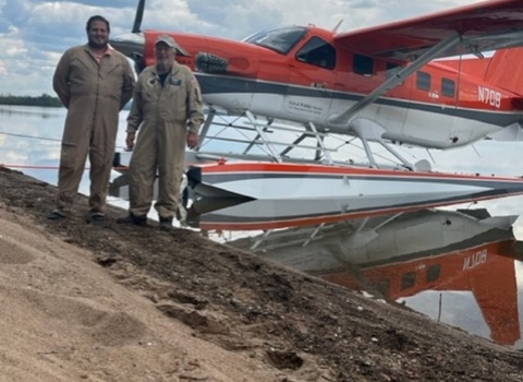 two people standing in front of an airplane