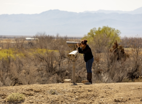 a woman looking through a spotting scope