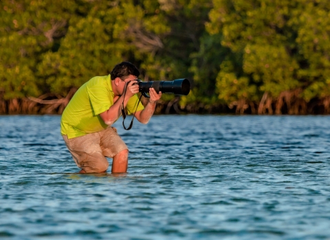 Ernesto Gomez taking photos of wildlife in a wetland