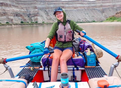 Woman rowing raft on river