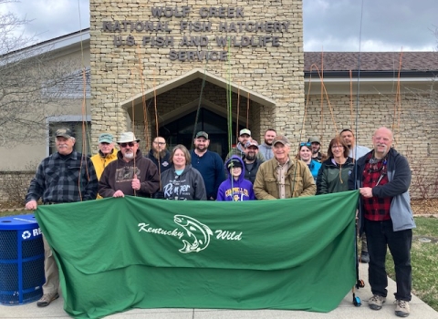 Group of anglers holding banner