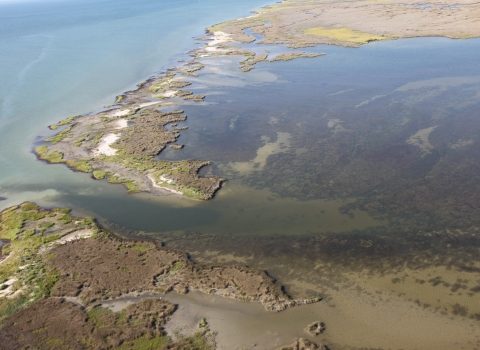 Aerial view of barrier island breach and coastal flooding.