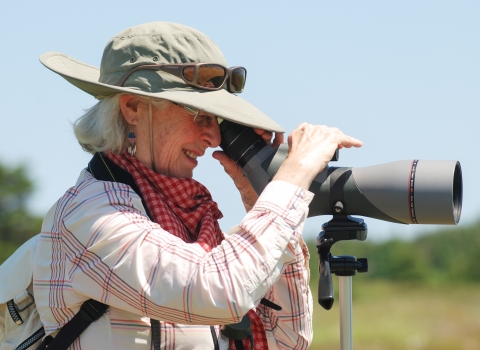 woman looks through a spotting scope