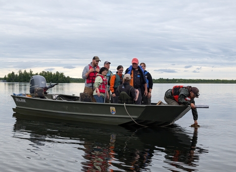 Biologist on boat sample for aquatic invasive species.