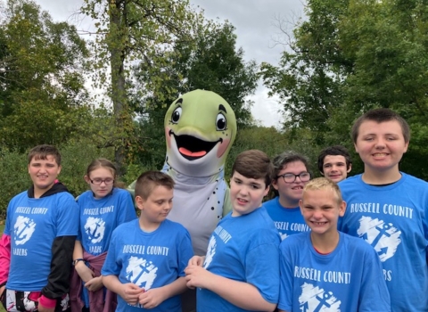 Group of kids smiling with fish mascot