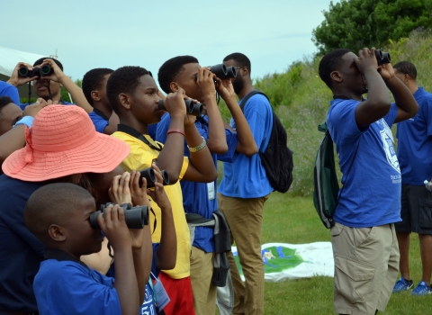 kids with binoculars looking toward trees