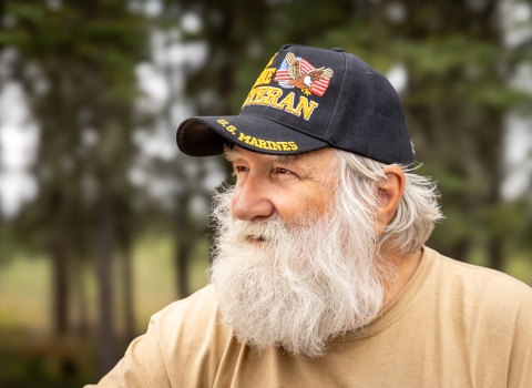 Man with a beard wearing a Marine veteran hat