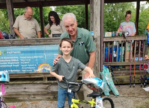 Man in uniform and boy posing with bicycle