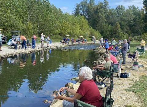 Elderly people fishing at stream