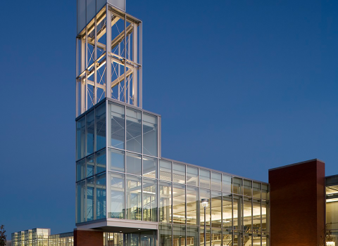 A building on a college campus illuminated by light at dusk